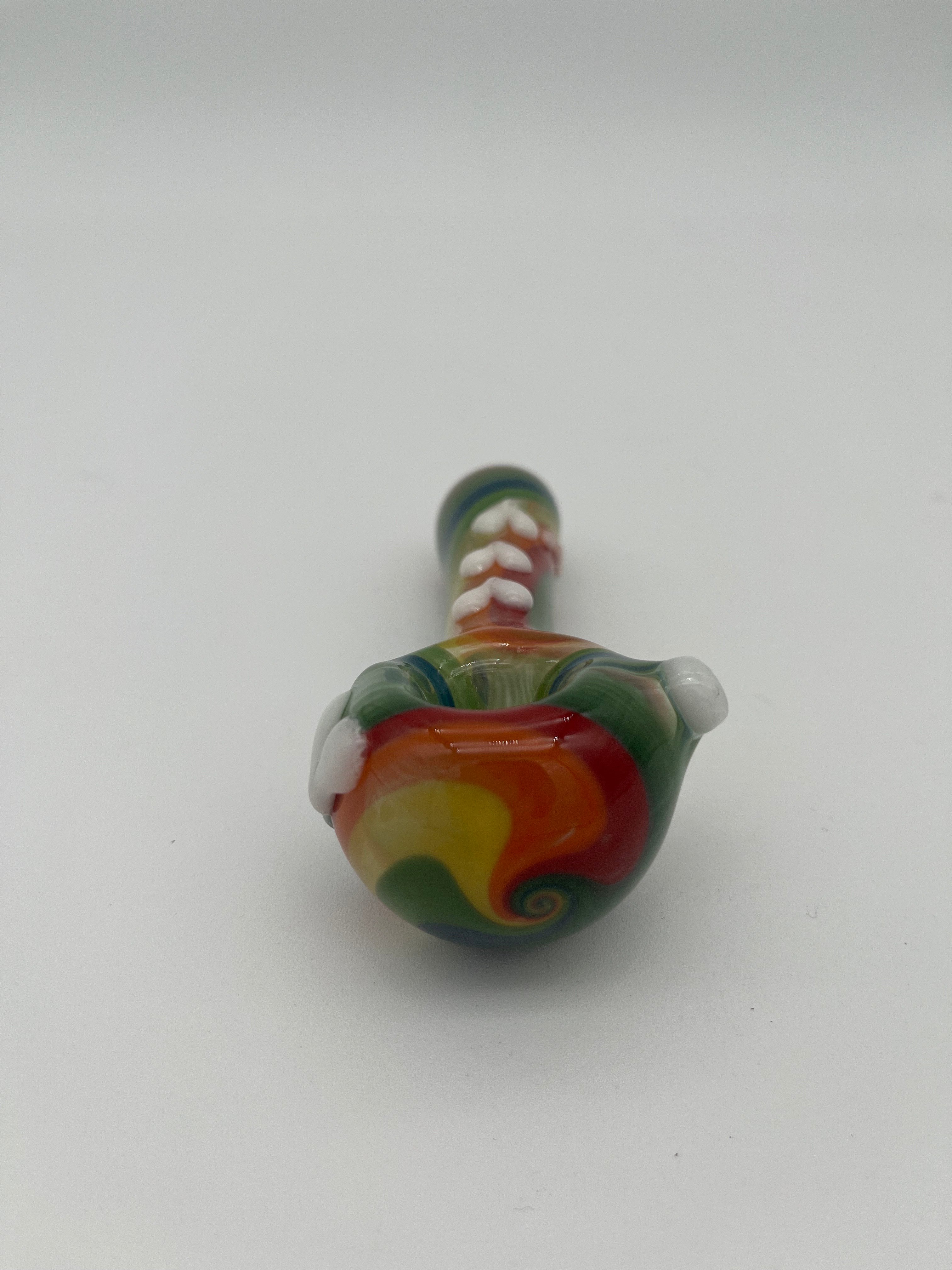 Rainbow glass pipe with white heart detailing on it displayed on a white background. Made by Kristi Conant.