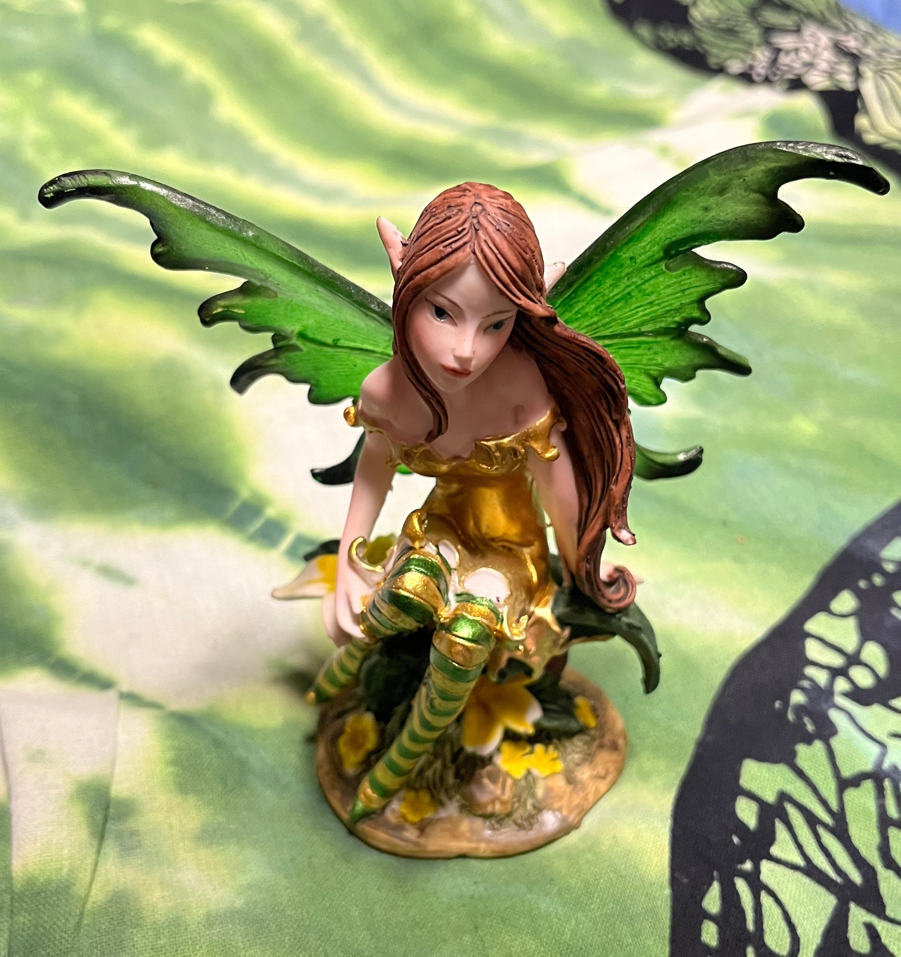 Fairy figurine with green wings on a decorative background