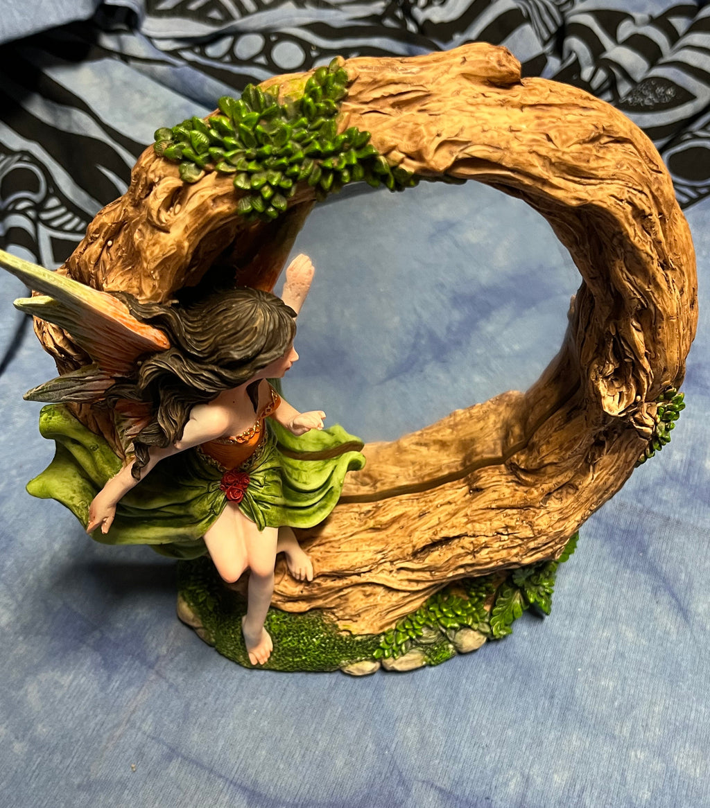 Decorative wreath with fairy figurines on a textured blue background